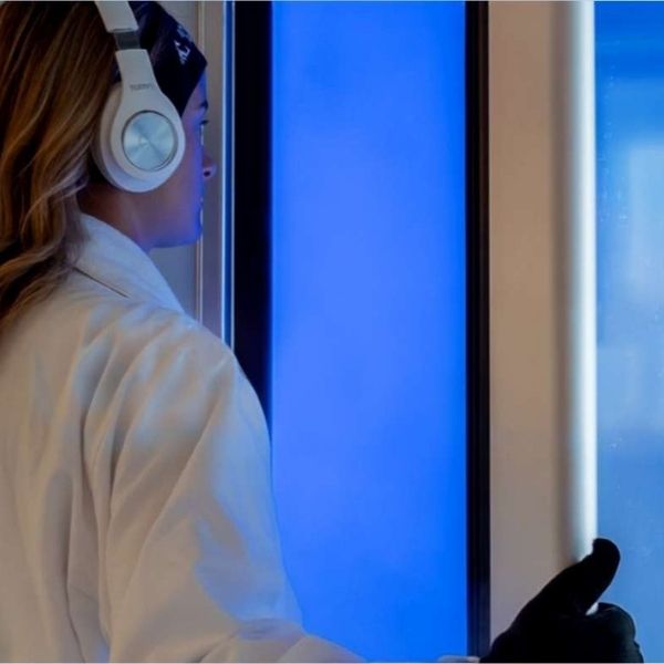 A woman preparing to walk in a full body cryotherapy room at Bonfire Wellness, as part of the contrast therapy approach.