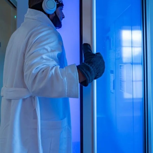 A man preparing to walk into a full body cryotherapy chamber at Bonfire Wellness.