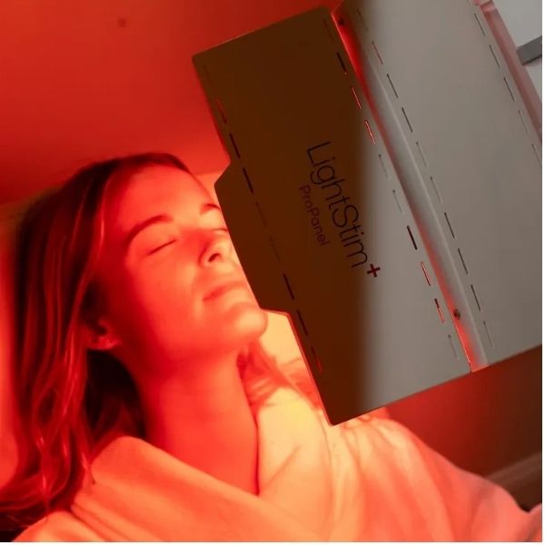 Close-up of a woman receiving red light facial therapy at Bonfire Wellness.