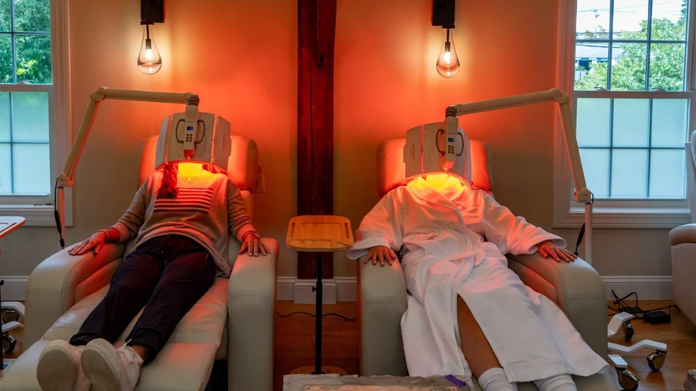 Two people relaxing through a red light facial therapy session at Bonfire Wellness.