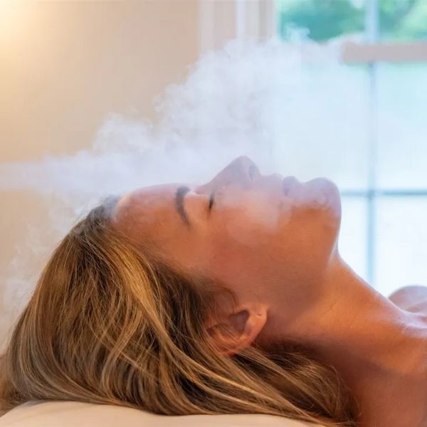 A woman receiving facial skin cryotherapy at Bonfire Wellness.