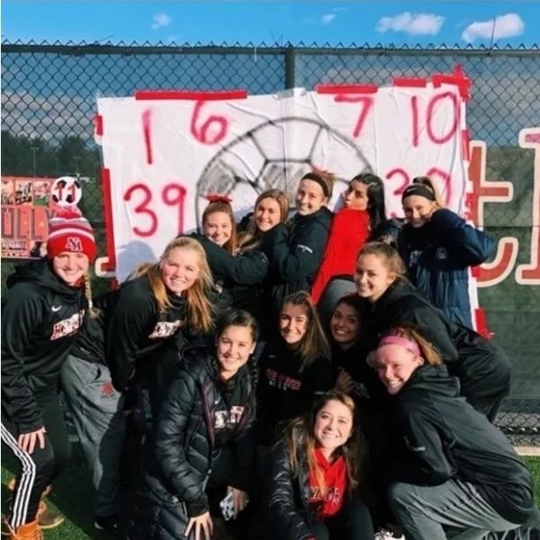 Group of student athletes and coaches posing together outdoors — Bonfire Wellness students, teachers, and coaches specials
