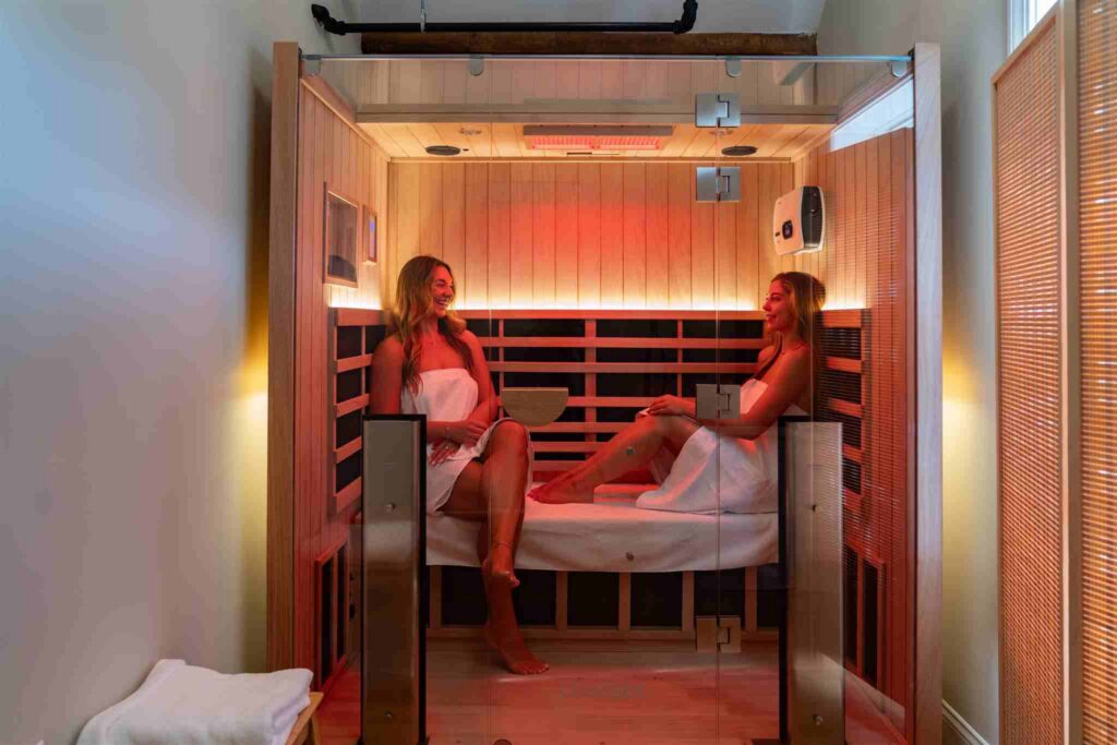 Two women enjoying a infrared sauna therapy session at Bonfire Wellness.